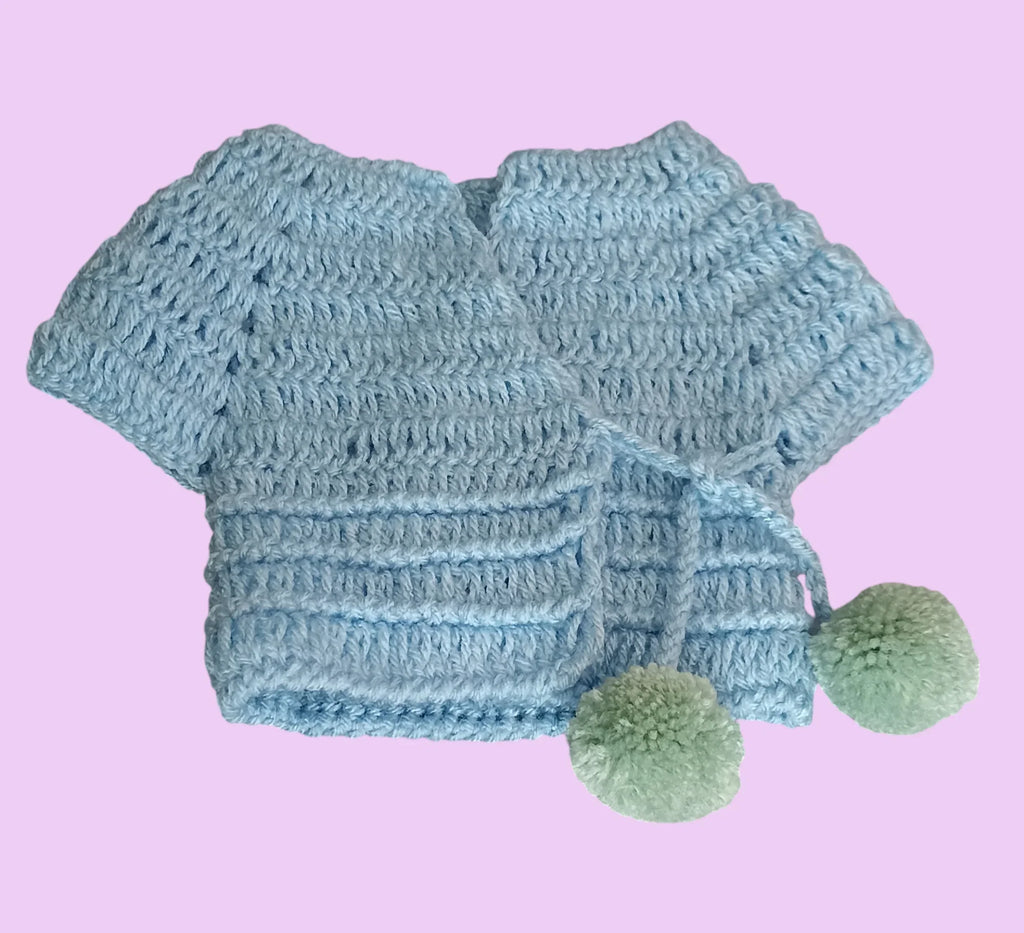 Handmade blue crochet baby cardigan with green pom-poms, Croch'pelotes by Sophie