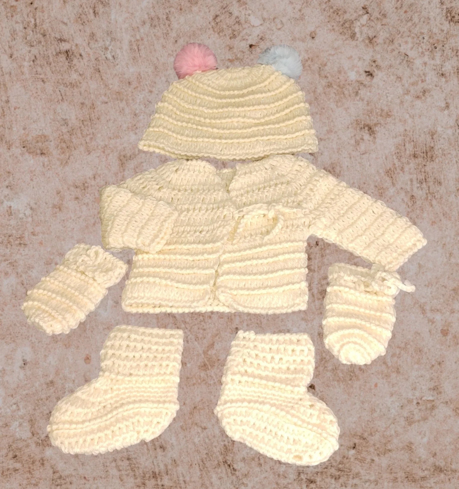 Handmade crochet baby set with cream cardigan, hat with pom-poms, booties, and mittens