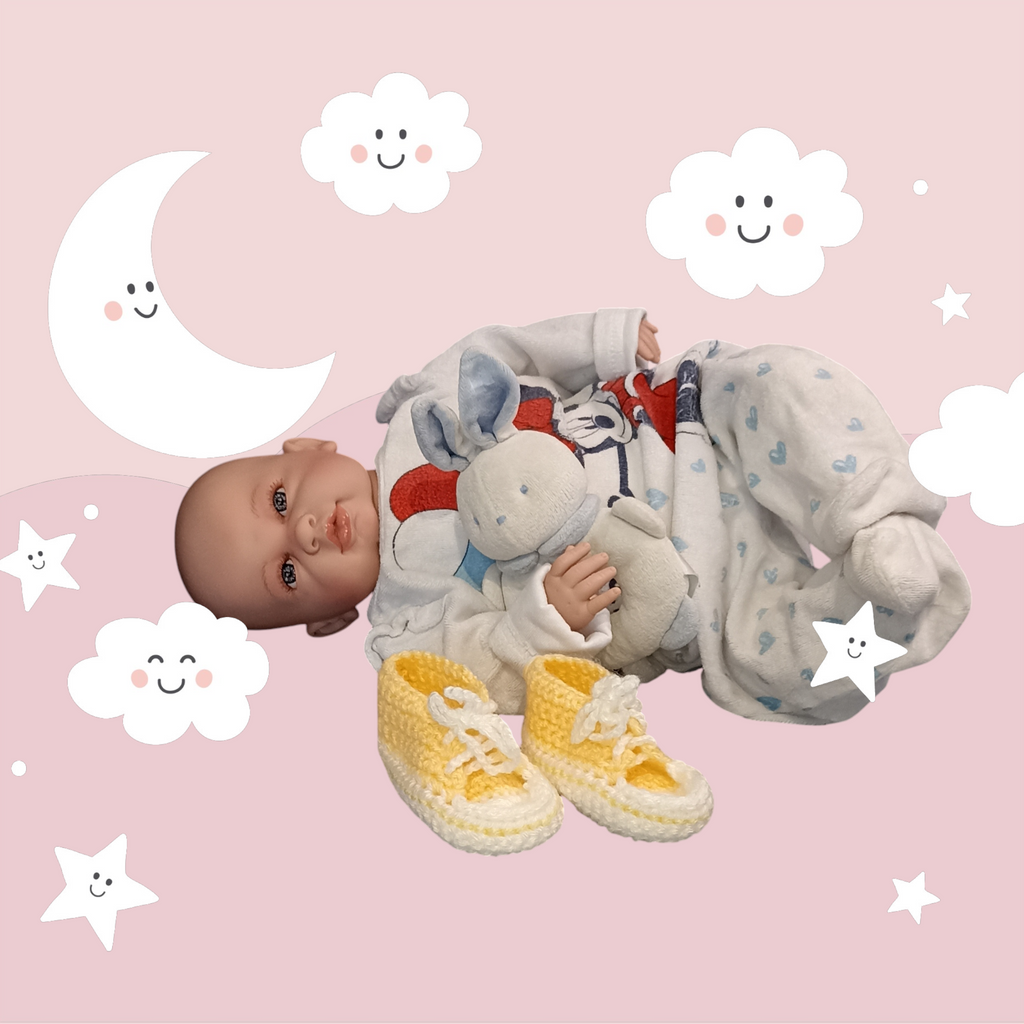 Handmade yellow crochet baby booties by Croch'pelotes by Sophie, with doll and plush toy.